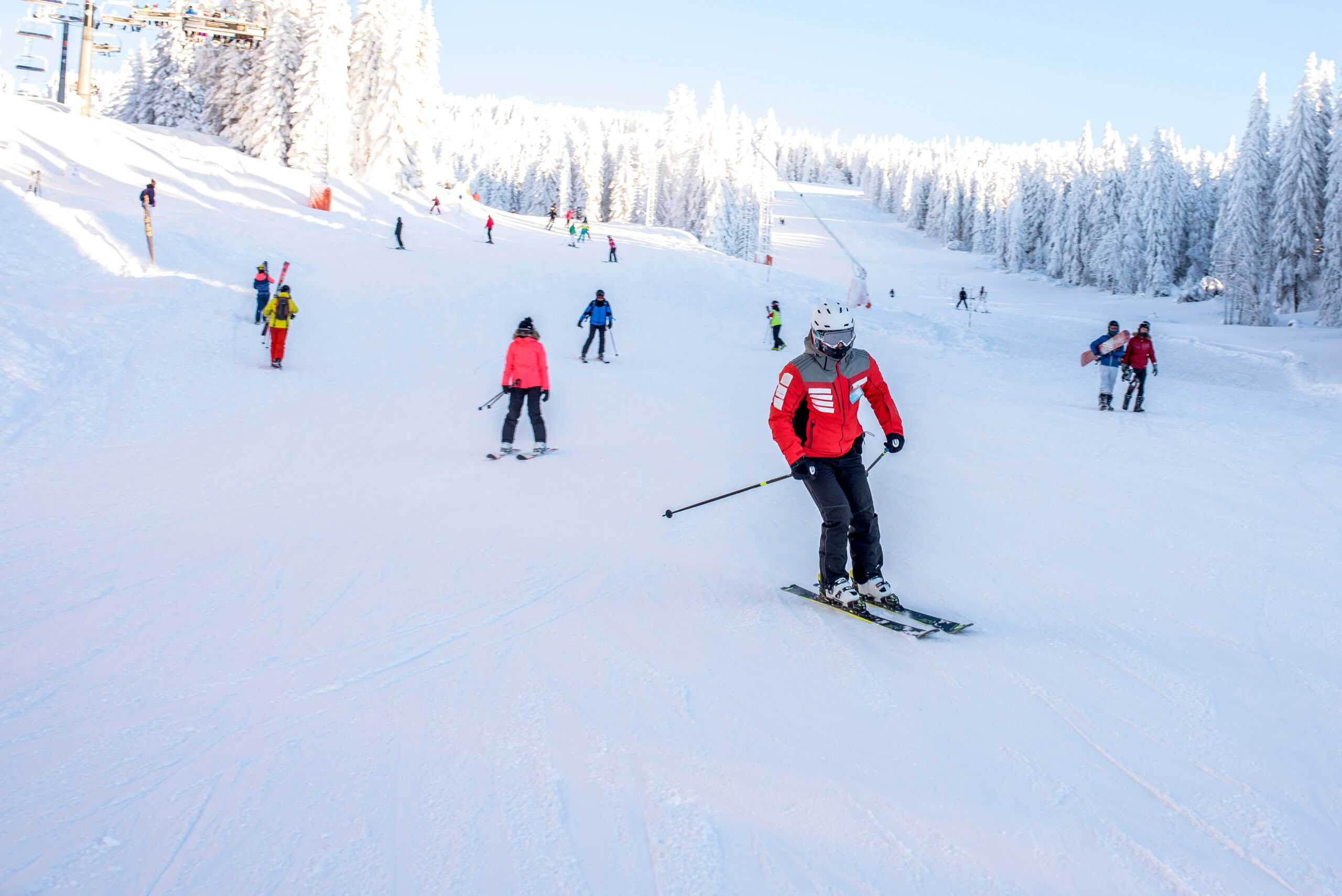 People enjoying skiing and snowboarding in mountain ski resort